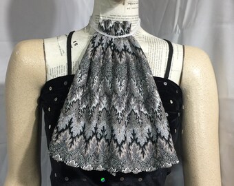 May include: A black velvet top with a silver and black patterned lace collar. The top is adorned with sequins.