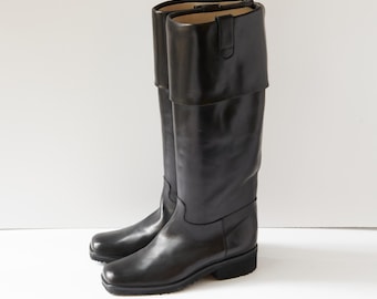 May include: Black leather knee-high boots with a fold-over top and a low block heel.