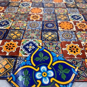 May include: A collection of colorful, hand-painted ceramic tiles with intricate floral and geometric patterns. The tiles are arranged in a mosaic pattern, creating a vibrant and visually appealing design.