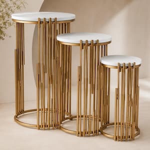 Puede incluir: Juego de tres soportes para plantas de metal dorado con tapas de mármol blanco. Los soportes tienen diferentes alturas y tienen una base circular y un diseño de varillas verticales. Adecuado para exhibir plantas o artículos decorativos.