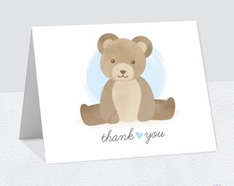 May include: A watercolor illustration of a brown teddy bear sitting on a light blue circle. The text "thank you" is written below the bear with a small blue heart.