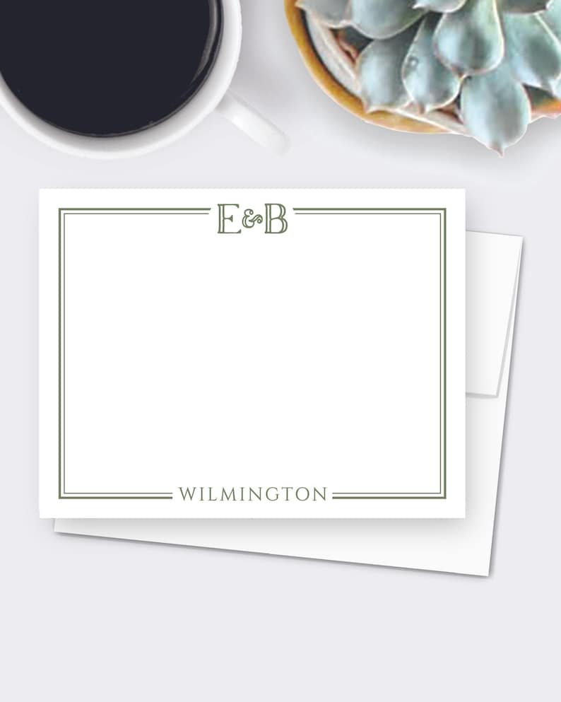 May include: White stationery with a green border and the initials "E&B" at the top. The word "WILMINGTON" is centered at the bottom. The stationery is on top of a white envelope.
