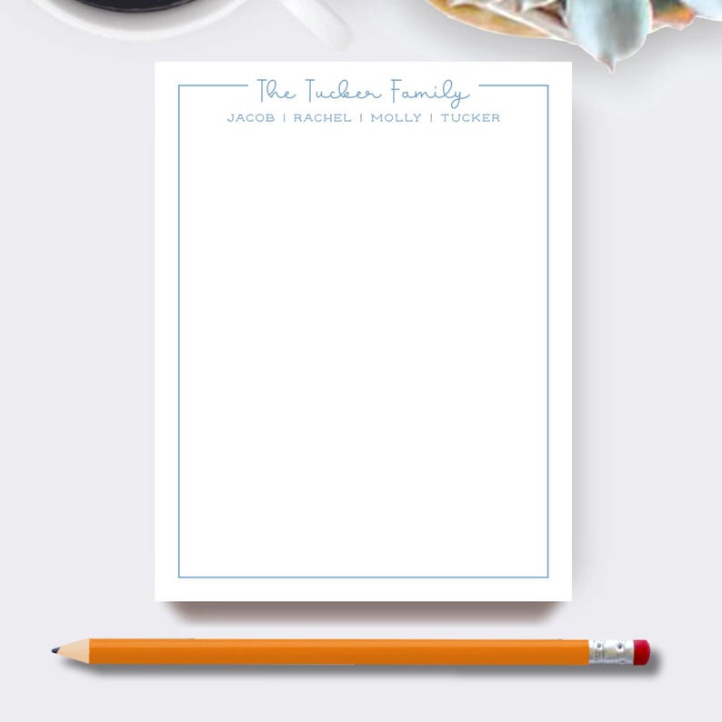 May include: A white notepad with a light blue border and the text "The Tucker Family" at the top. The names Jacob, Rachel, Molly, and Tucker are listed below. An orange pencil with a pink eraser rests at the bottom.