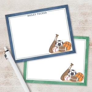 May include: Two blank note cards with a blue and green border. The top card has the name "BAILEY TUCKER" printed on it. Both cards feature a baseball bat, baseball, soccer ball, football, and basketball.