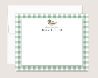 May include: A white stationery card with a green and white gingham border, featuring a watercolor illustration of a mallard duck at the top center. Below the duck, the text reads thank you from BABY TUCKER in dark blue and green ink.