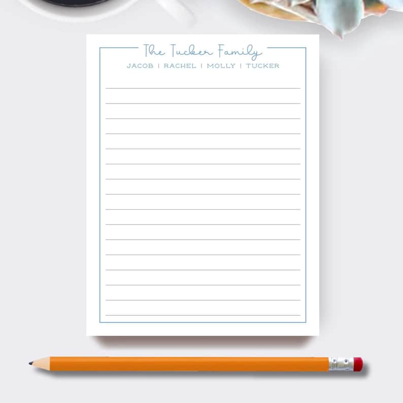 May include: A white notepad with a light blue border and the text "The Tucker Family" at the top. The names Jacob, Rachel, Molly, and Tucker are listed below. An orange pencil with a pink eraser rests at the bottom.