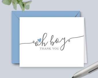 May include: A white thank you card with the text "oh boy" in gray script with a small blue heart above the "o". The text "thank you" is below the script in gray.