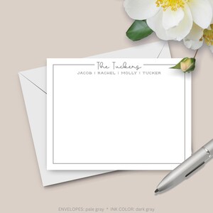 K&ouml;nnte beinhalten: Eine wei&szlig;e Karte mit schwarzem Rand und dem Text "The Tuckers" in Kursivschrift. Unter dem Namen steht "Jacob | Rachel | Molly | Tucker". Der Text "ENVELOPES: hellgrau * INK COLOR: dunkelgrau" befindet sich am unteren Rand der Karte.