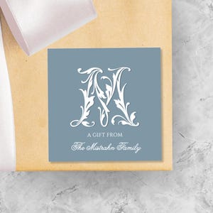 May include: A blue gift tag with a white decorative letter M and the text "A Gift From The Mistrahn Family".
