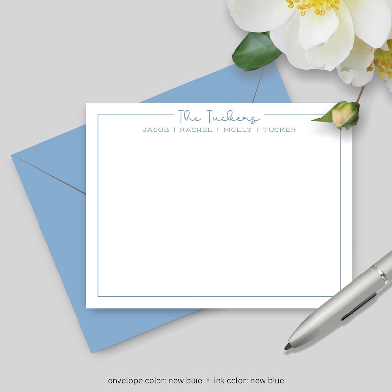 K&ouml;nnte beinhalten: Eine wei&szlig;e Briefpapierkarte mit einem blauen Rand und dem Text "The Tuckers" in blauer Schrift. Unter dem Namen steht "Jacob | Rachel | Molly | Tucker". Die Karte liegt auf einem hellblauen Umschlag und daneben liegt ein silberner Stift.