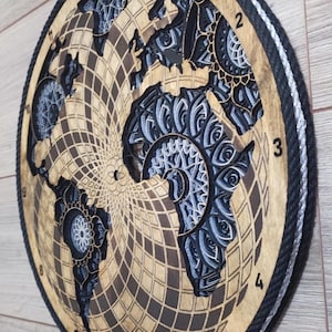 Peut inclure: Une horloge murale circulaire en bois présentant une carte du monde découpée au laser avec des motifs de mandala complexes superposés dans les continents. Le cadran a un fond quadrillé, des chiffres noirs de 1 à 12 et une bordure en corde noire.