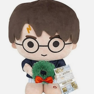 May include: Plush Harry Potter doll with brown hair, round glasses, and a lightning bolt scar. The doll holds a green wreath with a red bow and a paper with the text "Harry Potter".