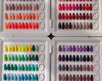 May include: A white case with four sections, each displaying a variety of artificial nail tips in different colors. The colors range from neutral tones to vibrant hues, including pinks, reds, greens, blues, and purples. The nails are arranged neatly, showcasing a wide selection of shades.