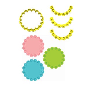 May include: Set of five cookie cutters, including three scalloped edge arches and two round cutters. The round cutters are pink with a heart pattern and green with a dot pattern. The arches are yellow.