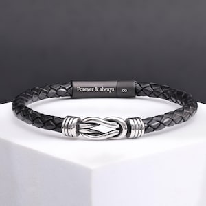 May include: Black leather bracelet with a silver knot clasp. The bracelet has the words "Forever & always" engraved on the clasp.