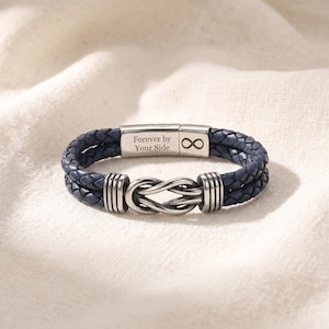 May include: A blue braided leather bracelet with a stainless steel clasp. The clasp is engraved with "Forever by Your Side" and an infinity symbol. The bracelet features a knot design and silver accents.