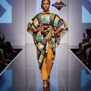 May include: A long-sleeved tunic with a vibrant patchwork pattern in black, yellow, green, and white, featuring a draped front overlay and a side knot. The tunic is paired with solid mustard yellow trousers and gold-toned strappy sandals.