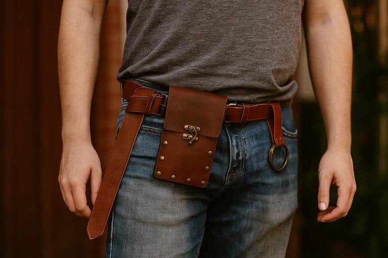 Puede incluir: Cintur&oacute;n de cuero marr&oacute;n con una funda a juego y un cierre decorativo. El cintur&oacute;n se lleva con vaqueros azules y tiene una correa larga colgando. La funda est&aacute; asegurada con remaches.