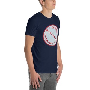 May include: A navy blue t-shirt with a white circle and red text that reads "Dundas Merchandise Intermediate 'X'".