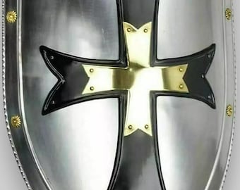 May include: A silver shield with a black cross and gold accents. The cross has a pointed design and is set against a silver background.