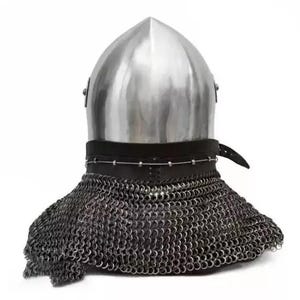 May include: A medieval helmet with a polished, silver-colored metal top and a chainmail neck guard. The helmet has a leather strap and is set against a white background. The chainmail is made of small, interlocking metal rings.