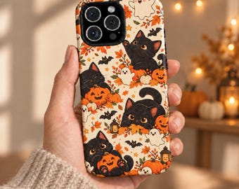 May include: A smartphone case featuring a cream-colored background with a repeating pattern of black kittens, orange pumpkins, small white ghosts, brown bats, and autumn leaves. The design includes small lanterns and orange foliage accents.