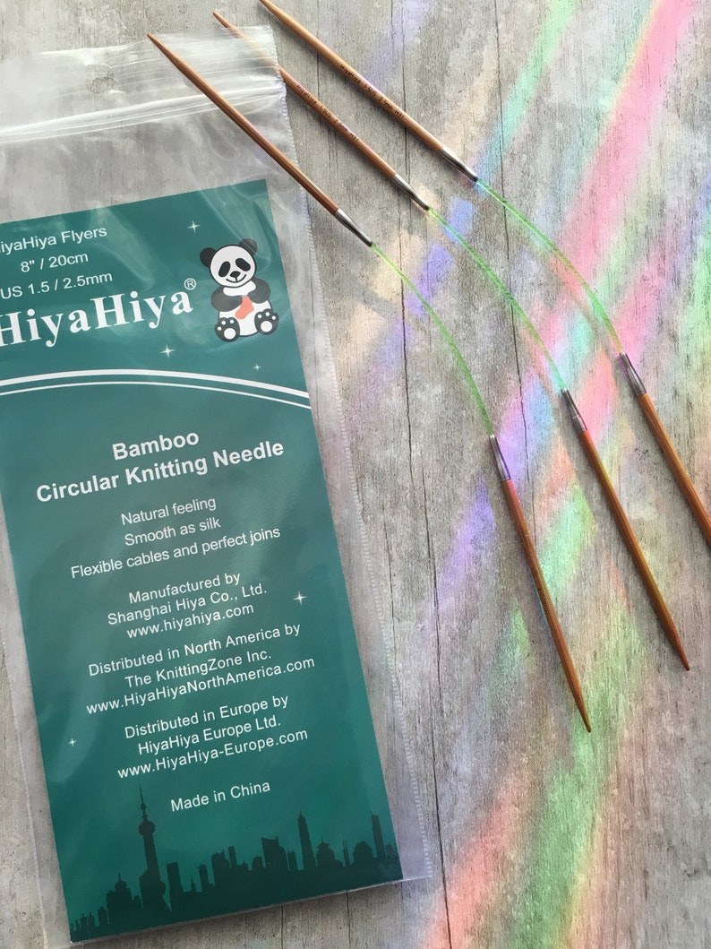 May include: A package of HiyaHiya Flyers bamboo circular knitting needles. The package includes a set of needles, 8 inches (20 cm) long, with a US 1.5 / 2.5mm size. The package has a panda logo and text that reads "Bamboo Circular Knitting Needle".