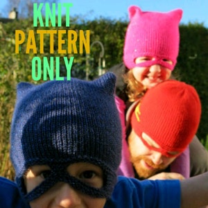 Puede incluir: Patrón de tejido para un gorro con agujeros para los ojos. El gorro es azul y tiene orejas de gato. El patrón es para un gorro de niño. La imagen muestra a tres personas usando los gorros. El texto "KNIT PATTERN ONLY" está en la imagen.