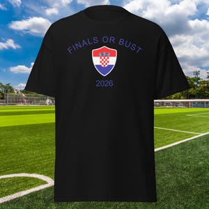 May include: Black t-shirt with the text "FINALS OR BUST" in white and a blue and red shield with the Croatian flag inside. The year 2026 is printed below the shield.