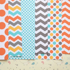 May include: A set of six patterned scrapbook papers. The papers feature a variety of patterns, including polka dots, chevron, and stripes. The colors are orange, yellow, blue, and gray.