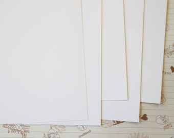 May include: Four sheets of white paper stacked on top of each other. The paper is smooth and has a slight sheen.