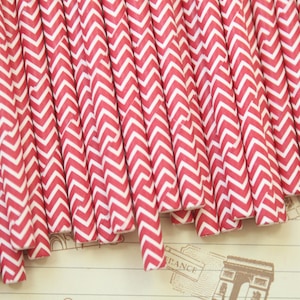 May include: A bundle of red and white chevron patterned paper straws.