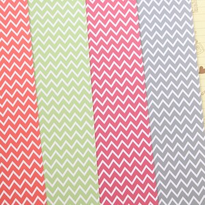 Pode incluir: Tr&ecirc;s folhas de papel com um padr&atilde;o chevron. O papel &eacute; em tons de coral, verde e cinza.