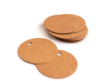 May include: A stack of round, brown paper gift tags with a hole punched in the top. The tags are blank and ready to be written on.