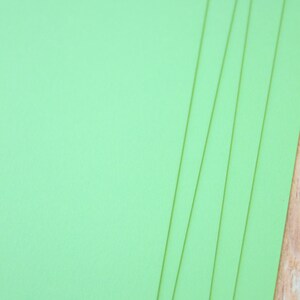 May include: Stack of five bright green sheets of cardstock paper.
