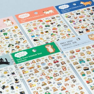 May include: Several sticker sheets with animal illustrations, including cats, Shiba Inus, and otters. The sheets have Japanese and English text, and are filled with small, detailed stickers for daily event scheduling. The stickers are in various colors.