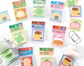 May include: A collection of colorful sticky notes in various shapes, including a turtle, pudding, and a tomato. Each pack contains 100 pieces and features Japanese text. The notes are packaged in clear plastic and are ideal for office or school use.