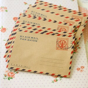 May include: A stack of brown envelopes with red and blue stripes and the text "BY AIR MAIL PAR AVION". The envelopes have a red and blue stamp with a design of a crown and the text "POSTE ITALIANE".
