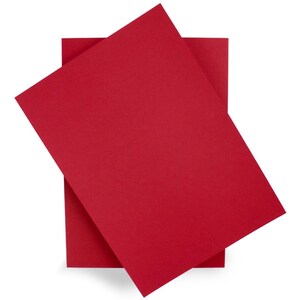 May include: Two sheets of vibrant red paper are arranged at an angle against a white backdrop. The paper has a smooth, matte finish. The top sheet is slightly angled, revealing a portion of the sheet beneath.