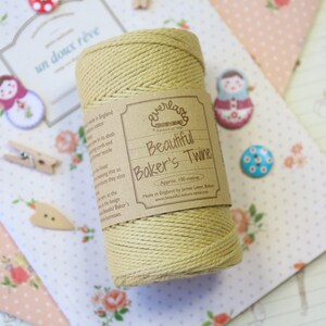以下が含まれることがあります： 「Everlast Beautiful Baker's Twine」というラベルが付いた、ナチュラルカラーの糸巻き。ラベルには「Approx. 100 meters」と「Made in England by James Laver Baker」の文字が書かれています。