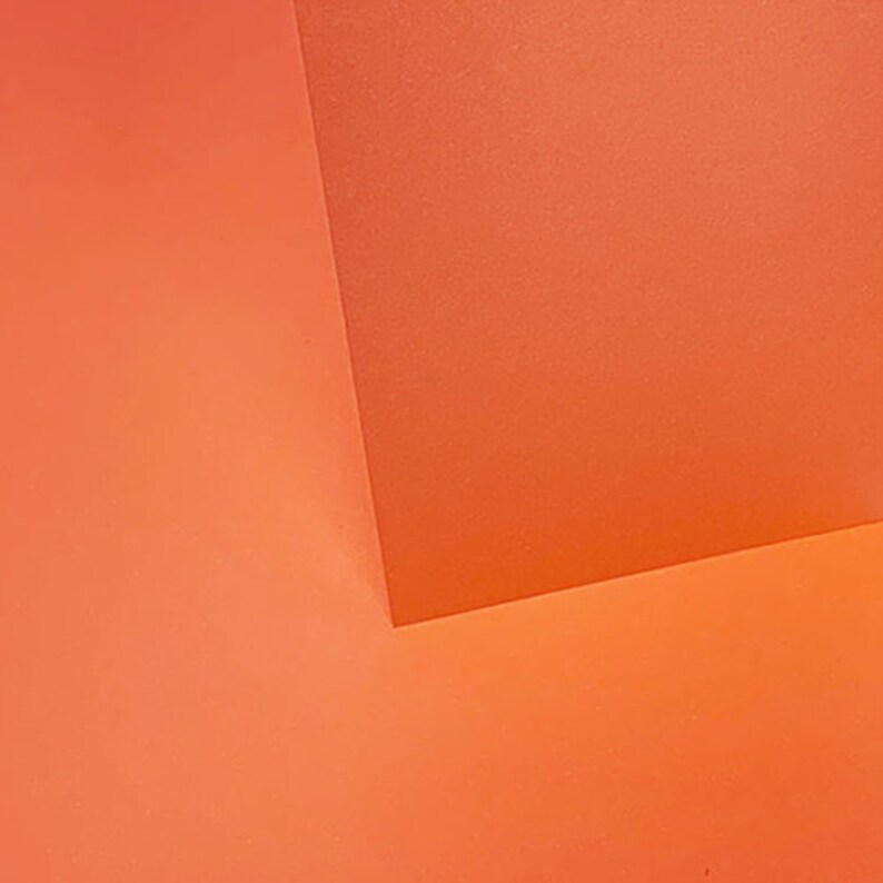 May include: Two pieces of orange colored paper meet at a corner, creating a geometric pattern.