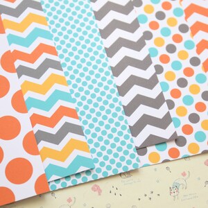 May include: Six sheets of patterned paper with different designs. The designs include orange and white polka dots, yellow and gray chevron, turquoise and white polka dots, gray and white chevron, turquoise and yellow polka dots, and orange and gray chevron.