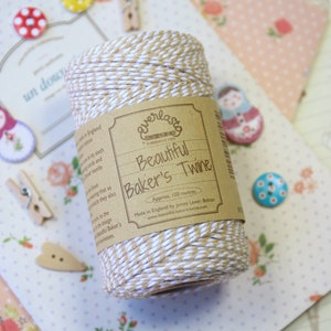 以下が含まれることがあります： 茶色と白のベーカーストワインのロールで、ラベルには「Everlasto Beautiful Baker's Twine」と記載されています。糸は約100メートルで、イギリスのボルトンにあるジェームズ・ロウによって製造されています。
