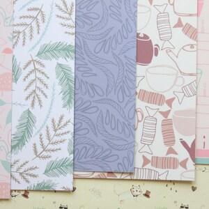 May include: Five different patterned sheets of wrapping paper. The patterns include pink and green birds, brown and green leaves, blue leaves, brown and pink teacups and candy, and pink and blue balloons and cakes.
