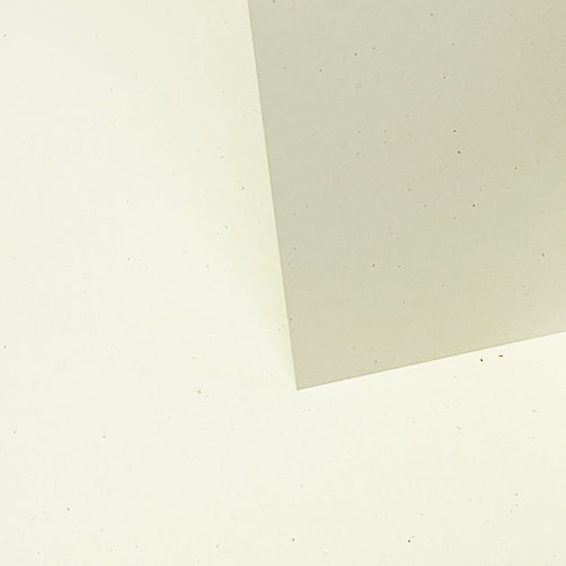 May include: Two pieces of paper, one white and one light gray, are placed on top of each other. The white paper is on the bottom and the gray paper is on top. The gray paper is slightly angled, creating a diagonal line across the image.