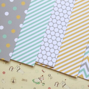 May include: Five sheets of patterned paper with different designs. The patterns include polka dots, stripes, and chevron. The colors are gray, yellow, and light blue.