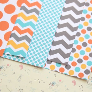 May include: A set of six patterned scrapbook papers featuring orange, yellow, gray, and blue colors. The patterns include polka dots, chevron, and stripes.
