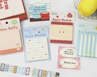 May include: A collection of colorful sticky note pads with various designs, including "Melon Buffy", "Fruit Melody", "Apple Sorbet", and "Sea Salt Lemon". The pads have 60 sheets each and are packaged with decorative tape and a book.