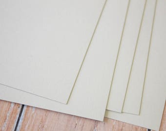 May include: Stack of five off-white cardstock sheets. The sheets are smooth and have a subtle texture.