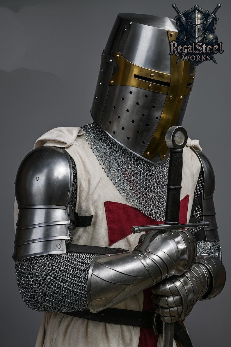 May include: A knight's full suit of armor, including a helmet with gold accents, chainmail, and metal shoulder and arm guards. The knight is holding a sword. The white tunic has a red cross. The Regal Steel Works logo is visible.